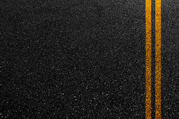 istock Double orange line on asphalt road 2223242473