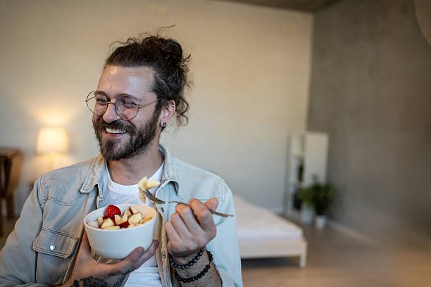 istock Happy man eating fruit salad at home 2223249579