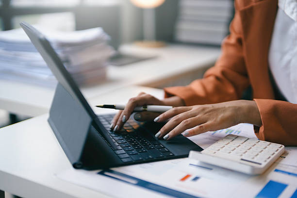 istock Professional businesswoman using modern technology at her well-lit office desk, surrounded by paperwork 2223249611