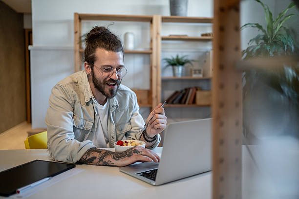 istock Freelancer enjoying breakfast and working on laptop at home 2223250139