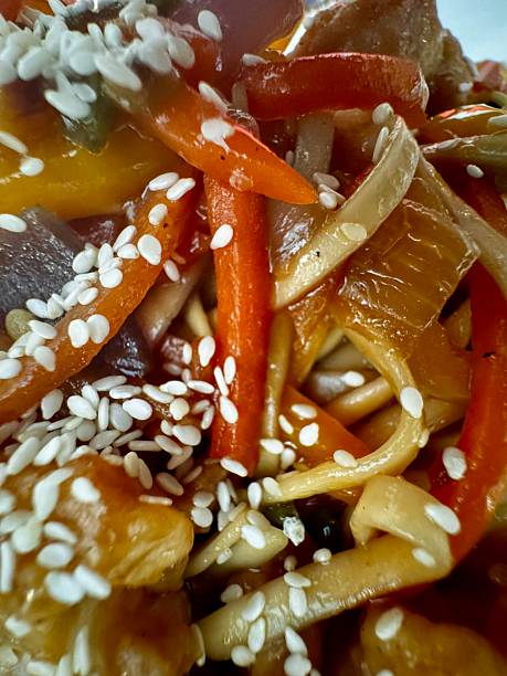 Close-up stir-fried asian food with carrots and chicken with sesame seeds