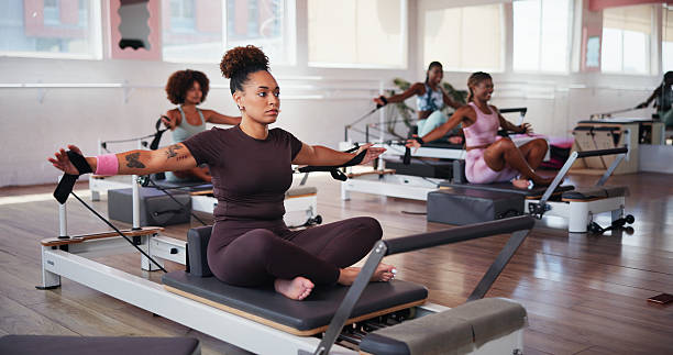istock Fitness, machine and pilates with woman in class for improvement, training or workout routine. Concentration, equipment and exercise with people on reformer in studio for challenge or performance 2223252868