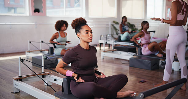 istock Fitness, pilates and reformer with people in class for improvement, training or workout routine. Concentration, equipment and exercise with woman on machine in studio for challenge or performance 2223252873