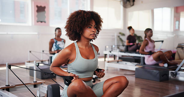 istock Exercise, pilates and reformer with woman in gym for improvement, training or workout routine. Class, concentration and fitness with serious person on machine in studio for challenge or performance 2223252902