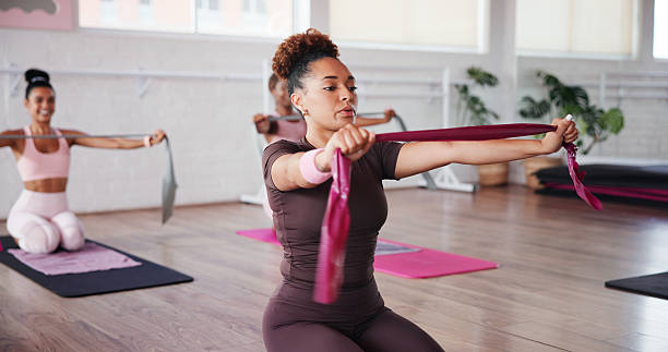 istock Exercise, stretching and resistance band with woman in studio for improvement, training or workout. Fitness, pilates and strength with people in gym class for breathing, challenge or routine 2223253012