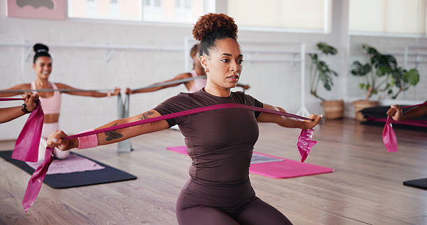 istock Pilates, stretching and women with resistance band in class for training, exercise and mobility. Fitness, gym and people with equipment for arm workout for wellness, health or challenge for strength 2223253014