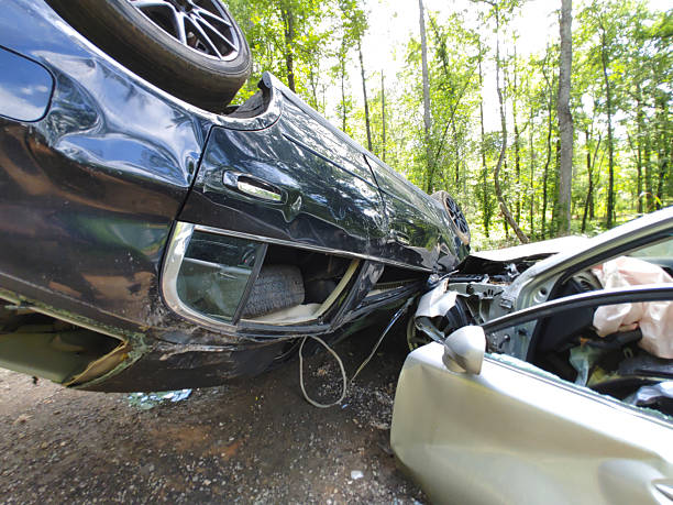 istock Car collision with overturned vehicle in wooded area 2223254172