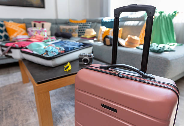 istock Pink suitcase ready for vacation with open suitcase on the table 2223254372