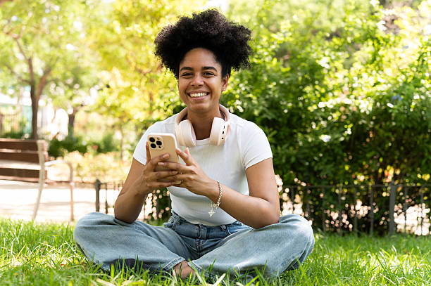 istock Woman using smartphone and smiling in the park 2223256405