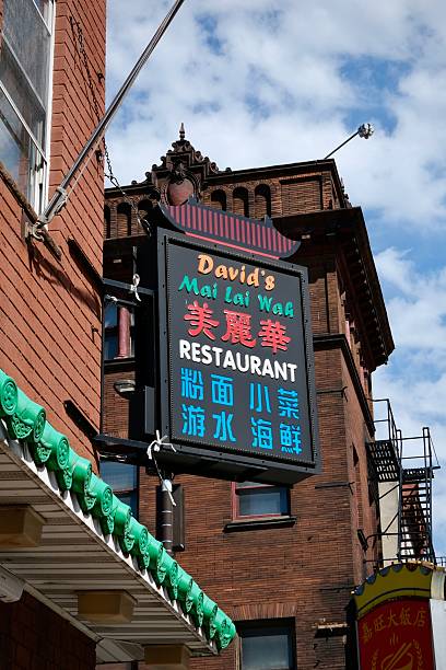 Philadelphia, Pennsylvania, USA- April 15, 2025: The ornate sign of David’s Mai Lai Wah restaurant hangs against a red brick building in Chinatown.