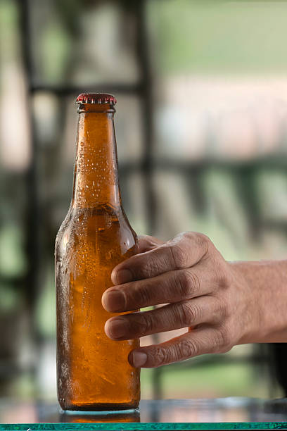 istock A young man's hand grasping a bottle of beer. 2223261397