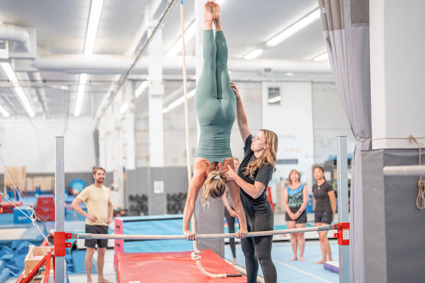 istock Gymnast Training Balance on Bars Under Professional Instructor Supervision in Gymnasium 2223263707