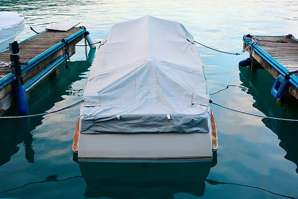 Small motorboat covered with a protective gray tarp