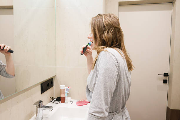 istock Woman Following Morning Bathroom Routine in Bathrobe 2223268524