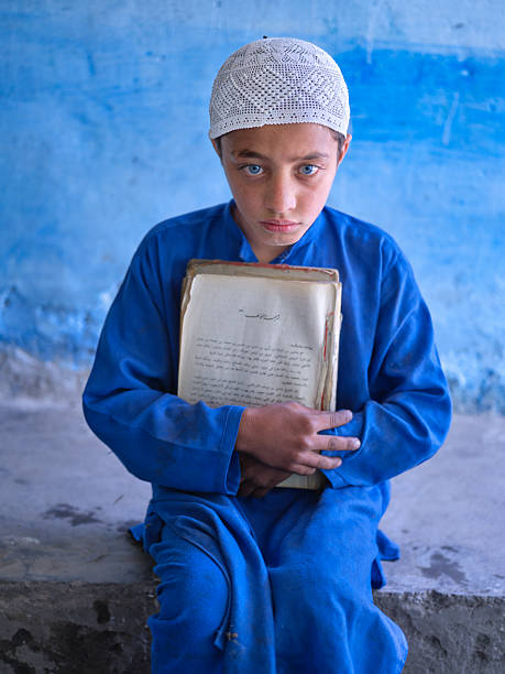 Muslim boy reading The Holy Koran in Mosque