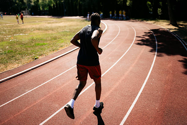 Young athlete running on a track and field oval during a training session