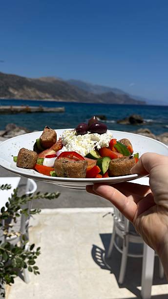 Greek Salad Held by the Sea on a Sunny Day