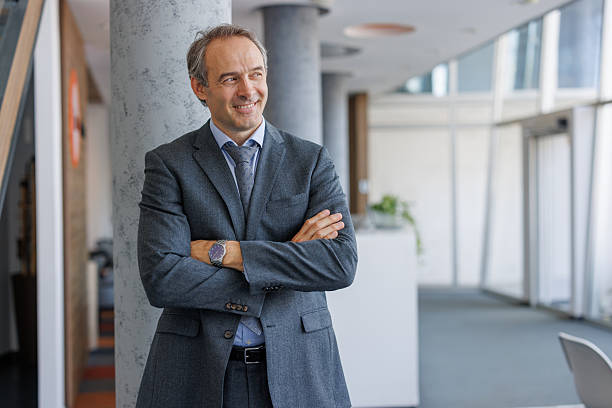 istock Confident businessman smiling with folded arms in modern office 2223273964
