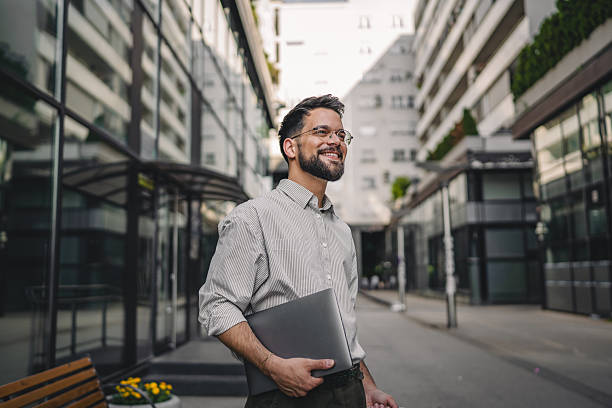 istock one man with beard and eyeglasses walk with suitcase and hold laptop 2223275468