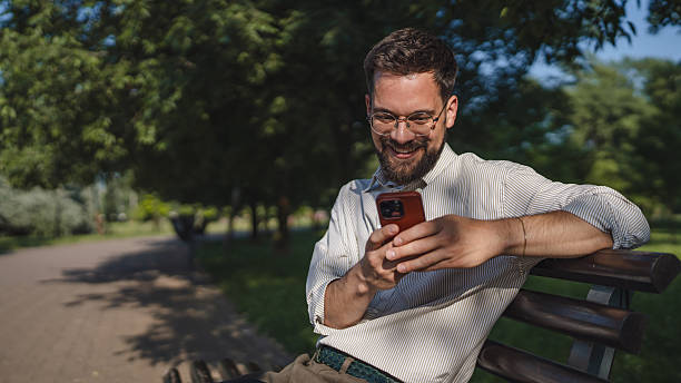 istock Adult man sit on bench in a public use mobile phone, leisure activity 2223276185