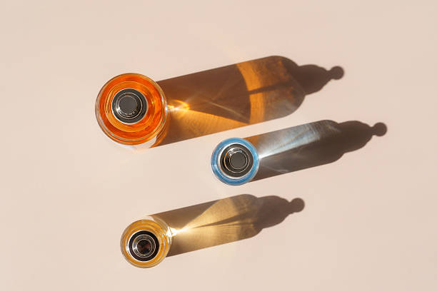 Colorful perfume bottles with bright refracted light and hard shadows from above overhead
