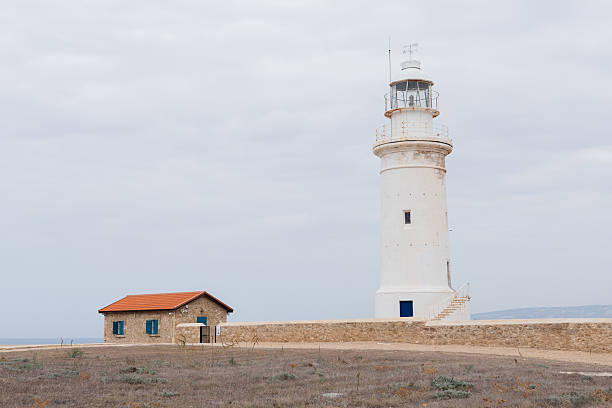 istock White lighthouse and small house under cloudy sky as a background 2223284326