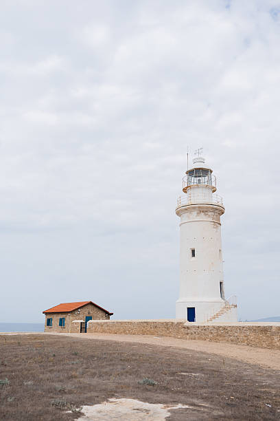 istock White lighthouse and small house under cloudy sky as a background 2223284327