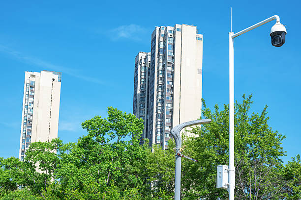 Security camera and modern city buildings with blue sky background