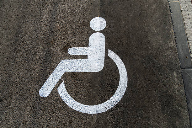 istock A white accessibility symbol is painted on a gray concrete surface, designating a parking space for individuals with disabilities in an urban setting 2223285795