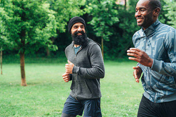 istock Cardio training outdoors. Happy athletes having fun while running together in nature. 2223286676
