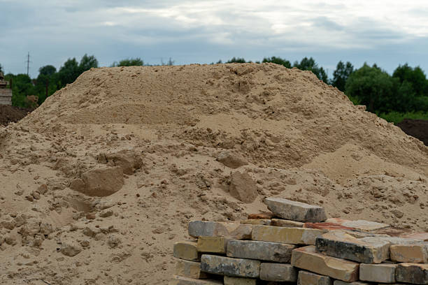 istock A significant mound of sand rises prominently beside neatly stacked bricks on a construction site. Overcast skies loom above, hinting at potential rain 2223287020