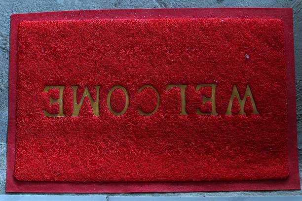 A vibrant red welcome mat greets visitors at the entrance way