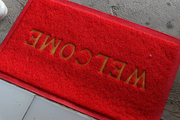 Vibrant Red Welcome Mat with Bold Inscription on Concrete Floor