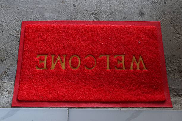 istock A bright red welcome mat laying on a grey tiled floor in a doorway 2223291328