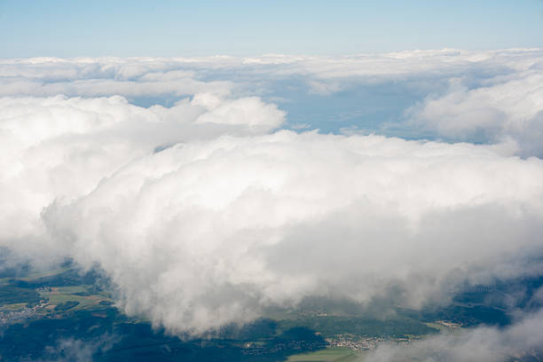 Aerial View of Thick White Clouds. Soft cloud formation above landscape. Useful for weather, travel, or nature backgrounds in digital or print projects.