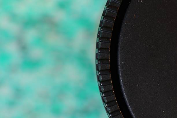 Close-up shot shows a black plastic lid against a blurred green background.