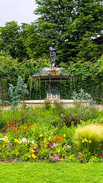istock Classical Statue Fountain in Lush Garden 2223295923