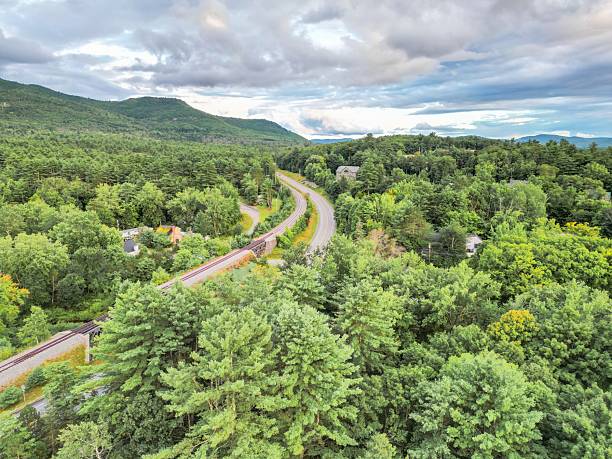 istock Scenic winding road through lush green forest with mountain views 2223297556