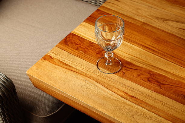 A stylish glass elegantly resting on a beautifully crafted wooden table that enhances the ambiance of the room