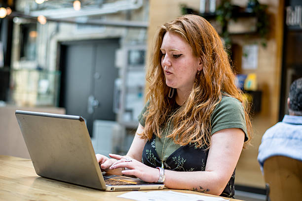 istock Remote Worker with Laptop and Paperwork at Coffee Shop 2223306113