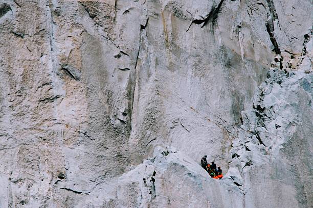 A group of hikers takes a moment to regroup on a natural shelf on the face of El Capitan in Yosemite National Park