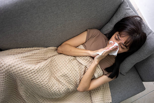 istock Ill Woman Lying on Couch Under Blanket 2223313256