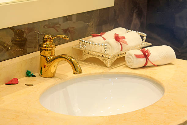 Aureate faucet and white towel, closeup of photo