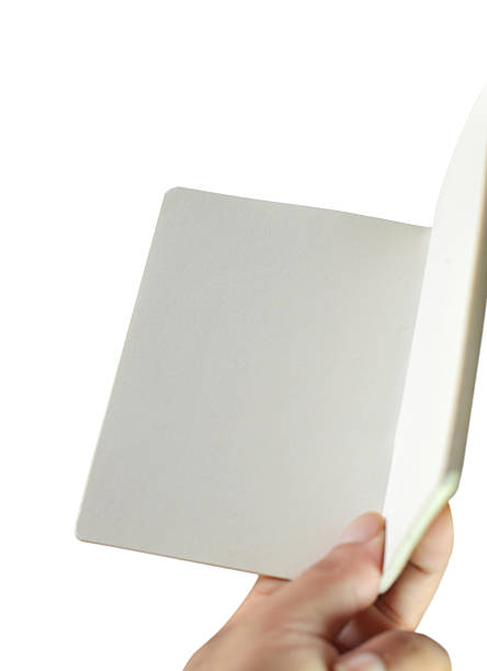 istock Cut out of close up a hand holding reading white plain paper blank empty page of open folded notebook notepad sketchpad isolated over white background with copy space 2223316461
