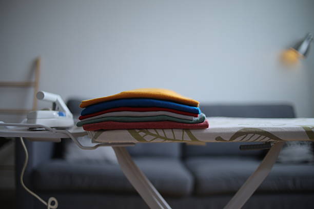 Selective Focus Of Folded Colorful Clothes On Ironing Board At Home