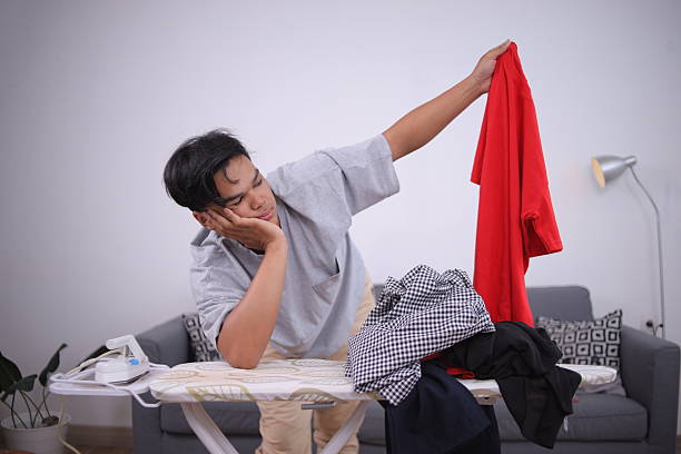 Lazy Careless House Husband With A Pile Of Laundry On The Ironing Board