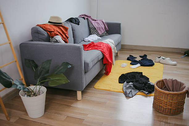 istock Dirty Clothes On Sofa And Floor 2223324340