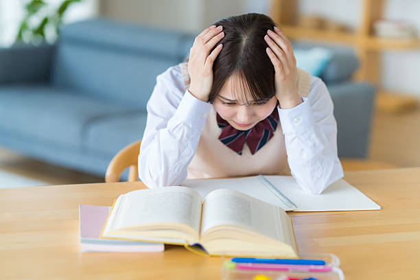istock High school girl worried while studying at home 2223326635