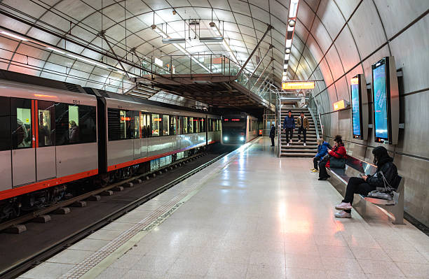 Bilbao, Spain, April 4, 2024: Modern underground platform of Bilbao metro with incoming train, seated passengers and illuminated signs, editorial image