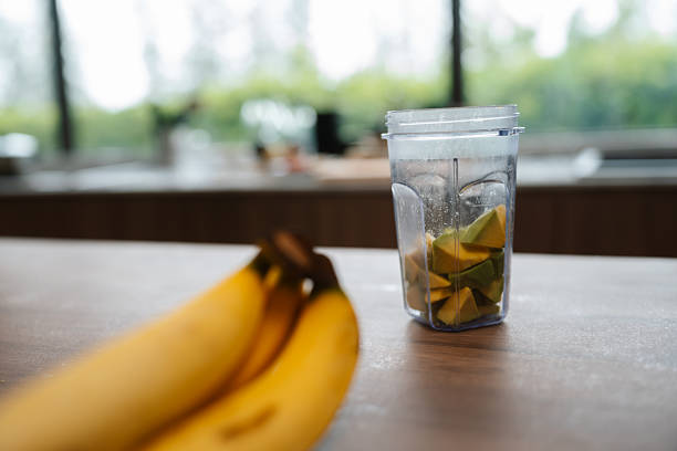 Messy kitchen counter covered with organic fruits, whole grains, and nuts, left behind after making a healthy smoothie. The ingredients are scattered, reflecting a moment of mindful cooking and a commitment to wholesome, eco-friendly living